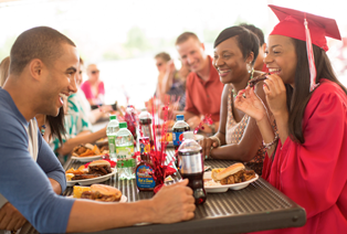 Graduates at a party with family eating Famous Dave's BBQ