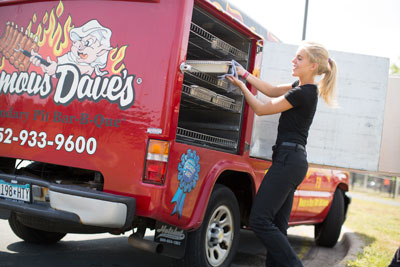 Famous Dave's BBQ Employee taking food out of a catering van