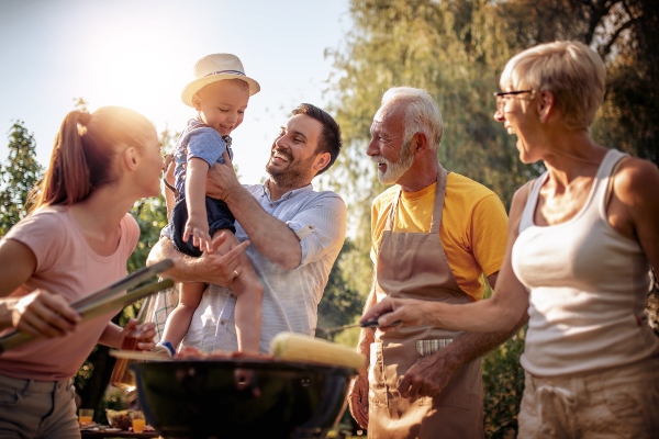 A smiling group of people enjoy a friendly, family bbq cook-off.